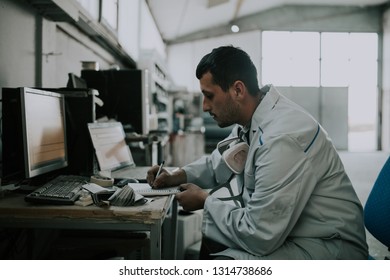 Car Repair Service. Worker Painter Checking Color Matching On Computer Before Painting.