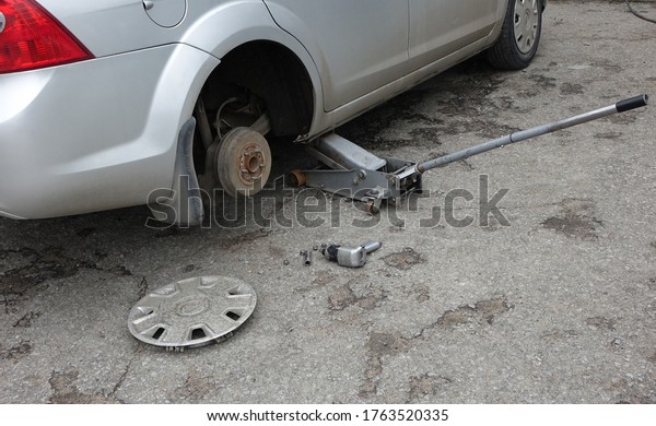  Car in repair - stands on a jack without a\
wheel                             \
