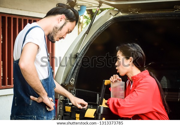 Car repair technicians find equipment or\
accessory at the back of pickup\
truck.
