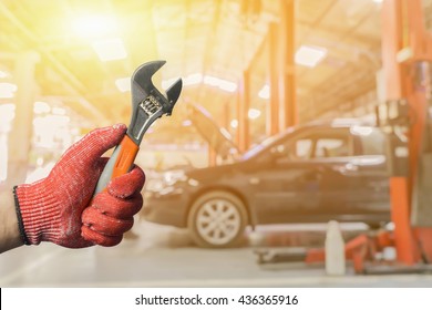Car repairing,Hand of car technician auto mechanic with a wrench working in garage. Repair service ,car repair station.vintage tone
