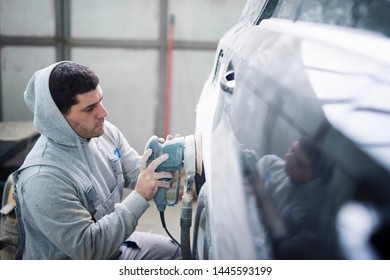 Car Repairman Grinding Car Body And Preparing Vehicle For New Paint. Collision Repair Service.