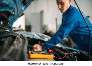 Car Repairman With Multimeter, Battery Inspection