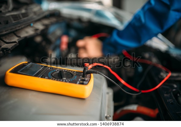 Car
repairman with multimeter, battery
inspection