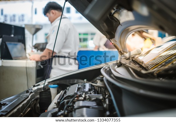 The car repairman in the service center is checking\
and analyzing the problem of the car by using a computer system to\
find the cause of the problem in order to check the condition for\
the customer to