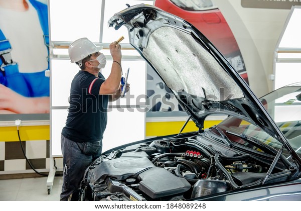 Car\
Repairmen is looking to the Cowling with light\
