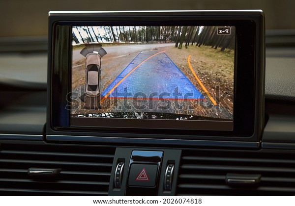 Car\
reverse parking sensor camera rearview monitor with dynamic\
trajectory turning lines and parking assistant steering wheel\
turned right. Help assist options of luxury\
car.