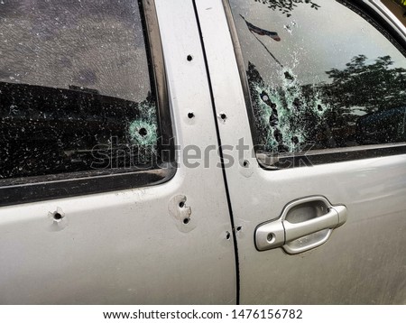 Car riddled with bullet holes .