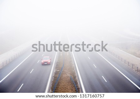 Car rides fast on a highway in a misty cold day. Concept of road safety problem.