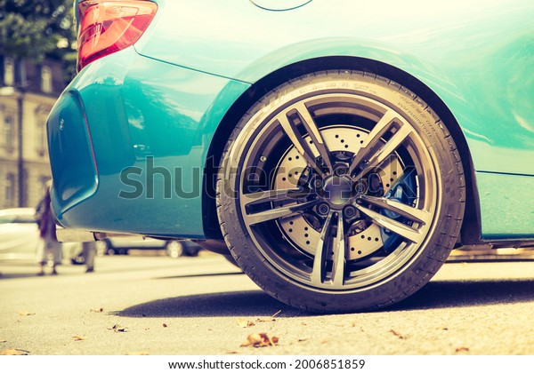 Car rim concept: Close up of expensive car\
rim with perforated front brake\
discs
