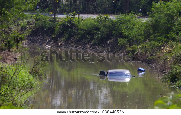 car in the river. Motor\
Vehicle Insurance Claim Themed Image.Damaged Car flooded in the \
river .
