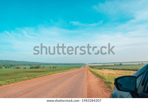 A car and a\
road into the distance to\
nature.