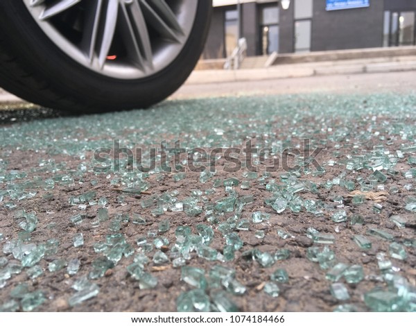 car robbery, hijacking, car theft, broken\
glass on asphalt on wheel\
background.