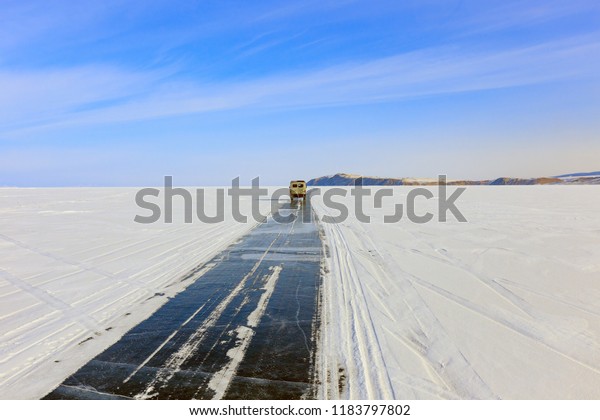 Car run on the ice road over\
Baikal lake in winter near Olkhon island, Irkutsk, Siberia,\
Russia.