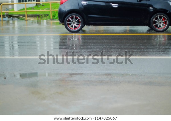 a car run on the\
wet road in raining day