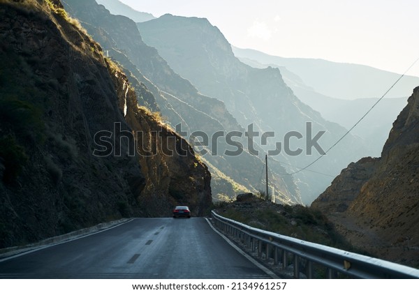car running on highway through the rocky mountains\
in sichuan province, china