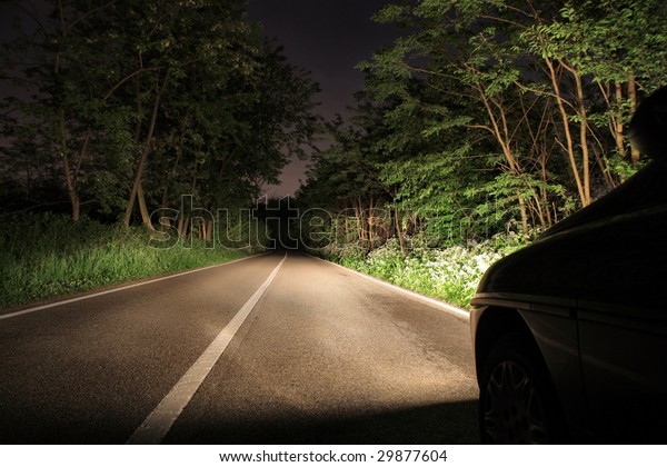 car running in a wood in\
the night