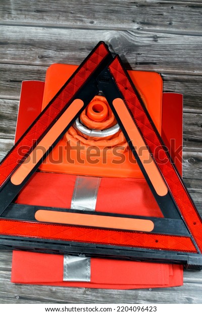 Car\
safety measures of warning foldaway reflective road hazard warning\
triangle, safety vest with reflective stripes, car traffic cone and\
phosphorescent reflective stickers, selective\
focus