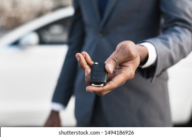 Car sale concept. Man in suit giving car key, focus on hand - Shutterstock ID 1494186926