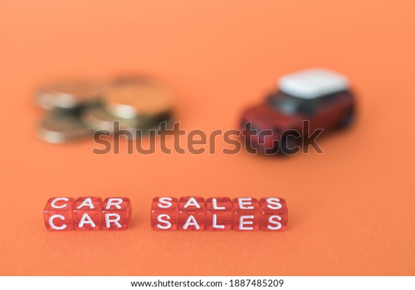 car sale from red cubes in the foreground,\
blurred red auto background and\
money