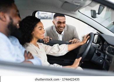 Car Sales.  Couple Choosing New Vehicle Talking With Dealer Sitting In Auto In Dealership Shop. Selective Focus