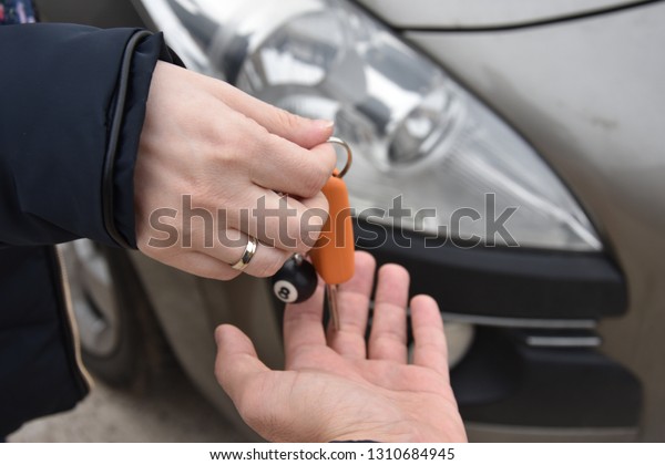 car sales. one person sells car and gives the key
to the new owner - Image