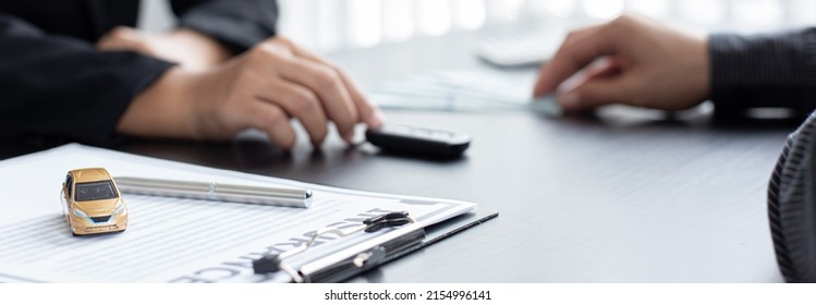 Car sales representative or sales manager submits a car key to a client who has approved financial loans with the company, Approval of financial and banking loans concept. - Shutterstock ID 2154996141