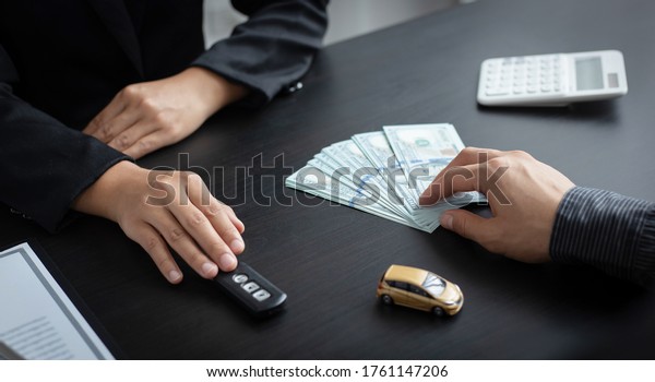 Car sales\
representative or sales manager submits a car key to a client who\
has approved financial loans with the company, Approval of\
financial and banking loans\
concept.