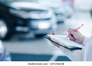 Car Sales Staff Are Writing Car Records In Stock In The Sales Representative Showroom., Taking Notes On New Cars In Stock., Taking Notes.