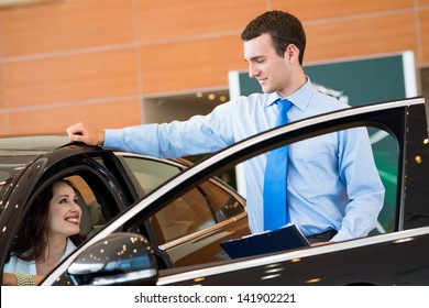 car salesman declares a young girl advantages of the new car