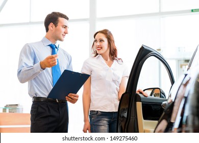 car salesman declares a young girl advantages of the new car
