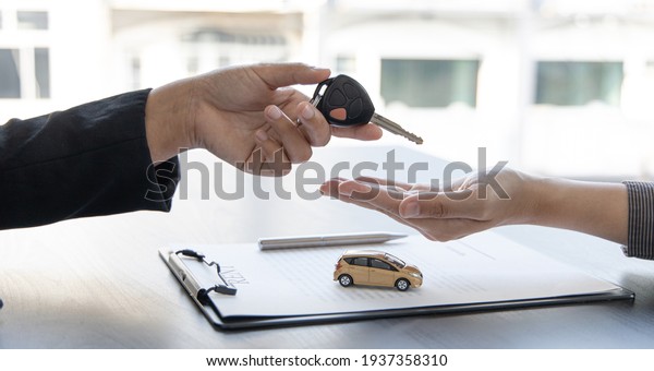 Car salesman gave the keys to\
the customers who signed the purchase contract legally, Successful\
completion of car sales, Purchase contract and key\
delivery.