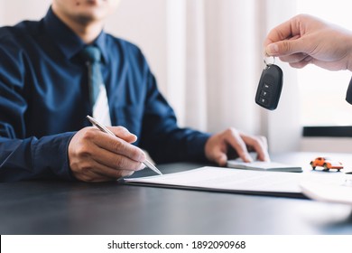car salesman handing over your new car keys, dealership and sales concept