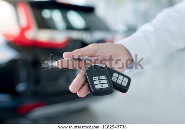car salesman handing over your new car keys,\
dealership and sales\
concept