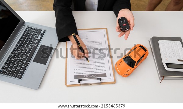The car\
salesman hands the keys to the customers who have signed the legal\
car sales contract. Sell the finished car and deliver the keys at\
the table in the top view sales\
office.