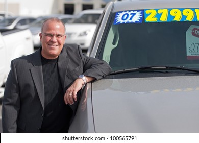 Car Salesman On Lot With Price Sticker On Cae Selling