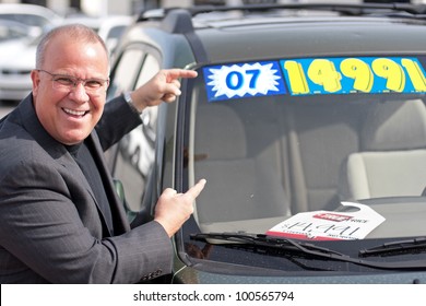 Car Salesman On Lot With Price Sticker On Cae Selling