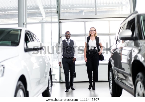 Car\
salesman shows the customer a new car in the\
showroom