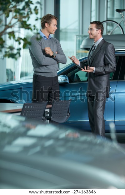 Car\
salesperson explaining car features to\
customer