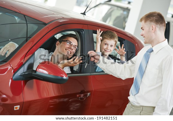 Car salesperson sells new automobile to young
family with child