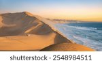 Car in the sand dunes and ocean view in Sandwich Harbour, Namib Naukluft Natural Park landscape in Namibia, Africa