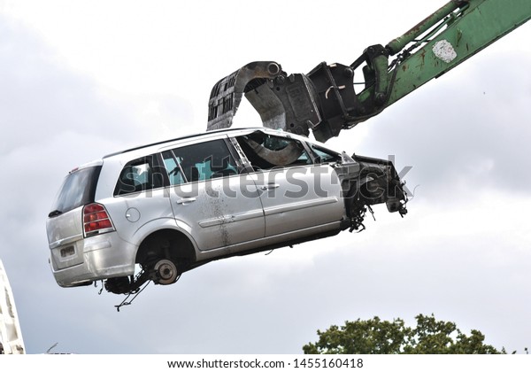 Car in a scrap yard being lifted by a\
mechanical grabber crane to be scrapped\
