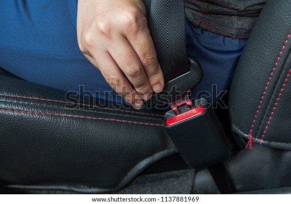 Car seat belt. woman fastens the seat belt
on car Safe driving. Safety belt in hand.
