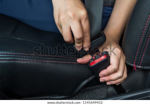 Car seat belt. woman fastens the seat belt\
on car Safe driving. Safety belt in hand.\
