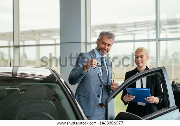 car sell agent\
with client in car showroom