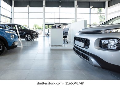 Car Seller's Station And Parked Cars In The Interior Of A Modern Dealership