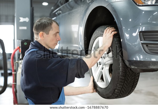 Car service mechanic repairing and maintenance a\
lifted checks the suspension Car repair and maintenance concept at\
car service center