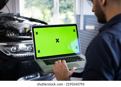 Car service mechanic uses laptop computer with green screen mock up chroma key car diagnostic software. Car Scanner Computer Diagnostics. Automotive Electronic Diagnostic.