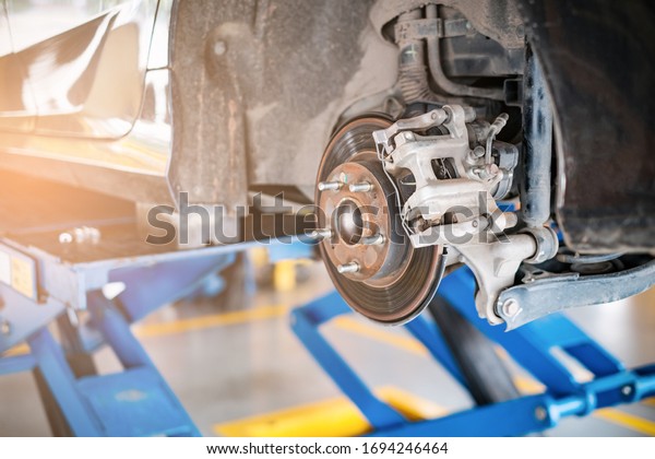 car in for service mot replacing wheel and\
repairment, in vehicle work shop with suspension, tools and\
equipment fixing broken parts, concept of repair, auto mechanic\
shop and car external\
interior
