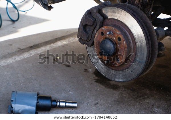 Car service\
and repair. Repair of a broken wheel. Balancing. View of the car on\
the dock with the wheel\
removed.