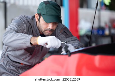 Car Service, Repair, Maintenance Concept - Arab Auto Mechanic Man Or Smith Checkingrepair Machine At Workshop Warehouse, Technician Doing The Checklist For Repair Machine A Car In The Garage